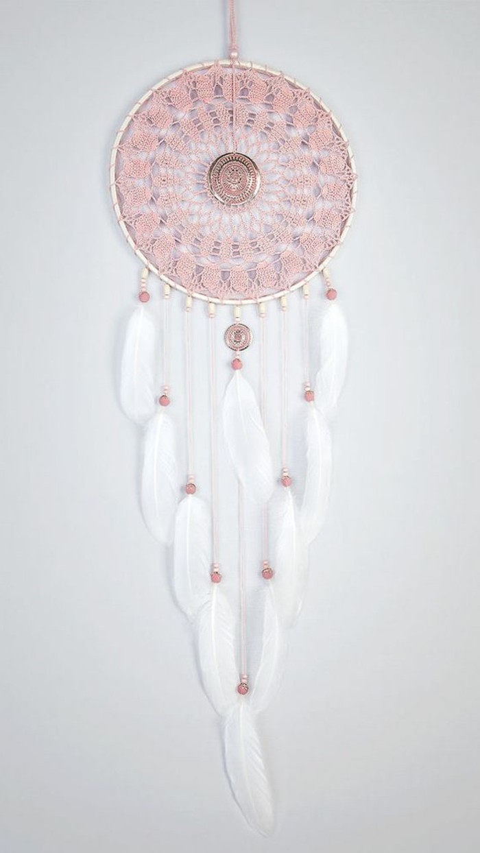 un modello di dream catcher con l'interno del cerchio rosa in pizzo e delle piume con perline decorative