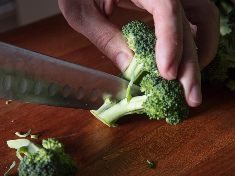 Come tagliare i broccoli con coltello su un tagliere di legno, primi piatti dietetici facili da preparare 