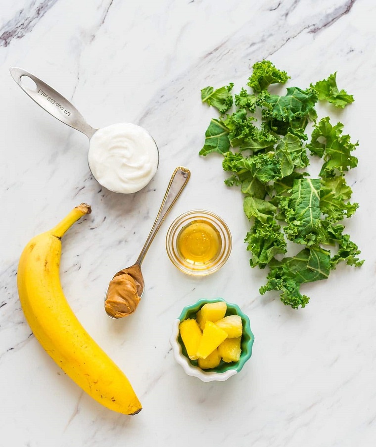 Ingredienti per la preparazione di un frullato con banana, yogurt e insalata, mango e miele come aggiunta 