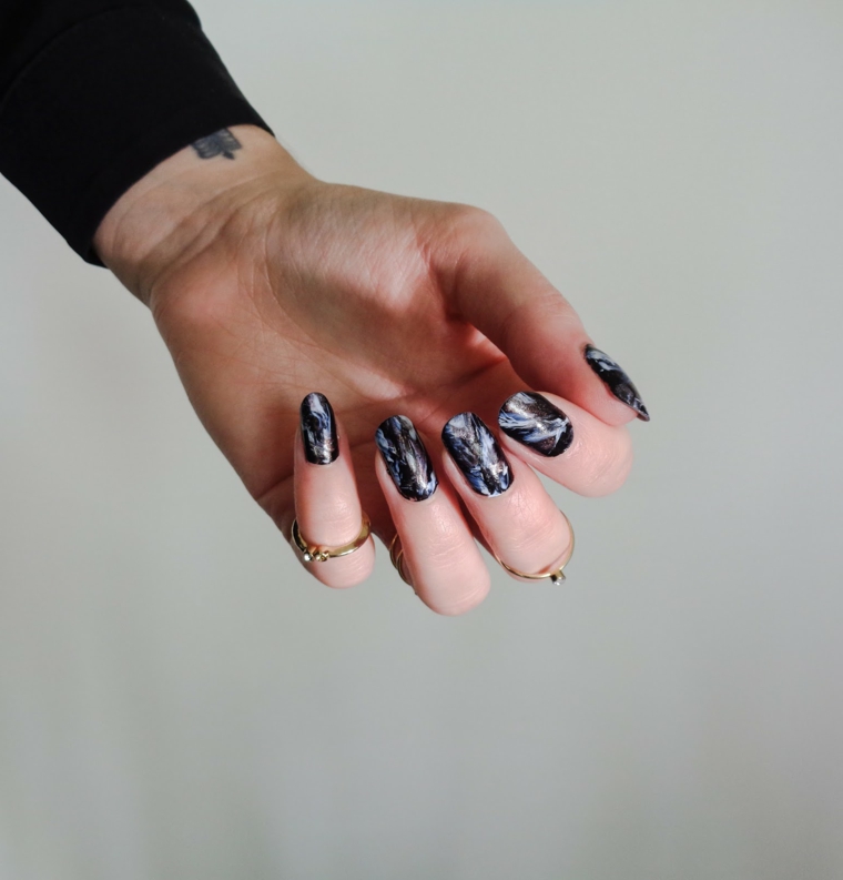 Unghie a mandorla effetto marmo con base nera, decorazioni unghie, tatuaggio polso 