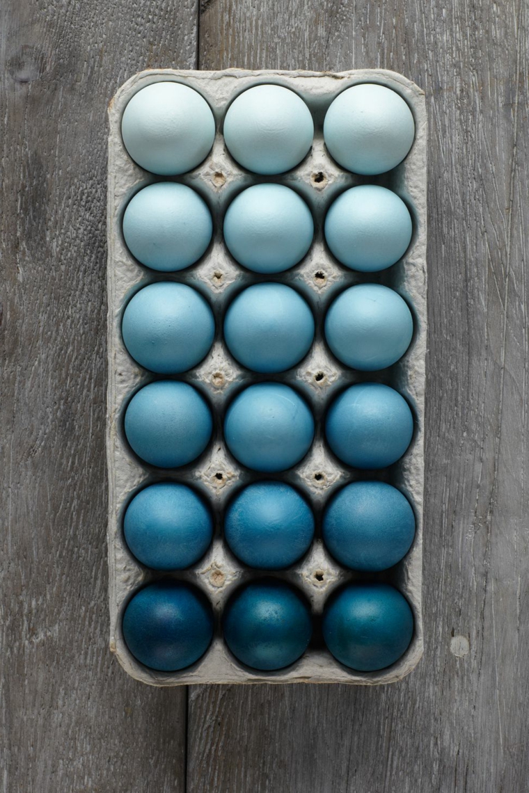 Colore blu in diverse sfumature, uova di Pasqua tinte, tavolo di legno rustico 