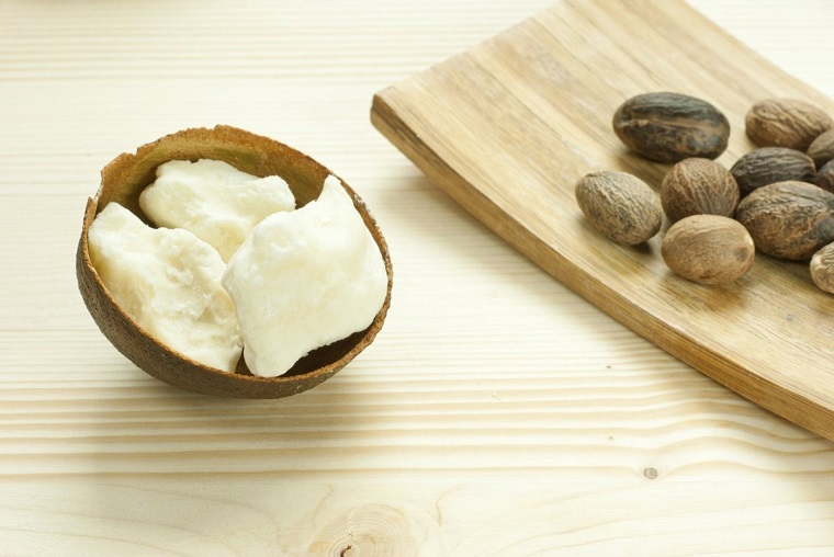 Ingrediente burro di karitè per la crema, tagliere di legno su un tavolo di colore chiaro
