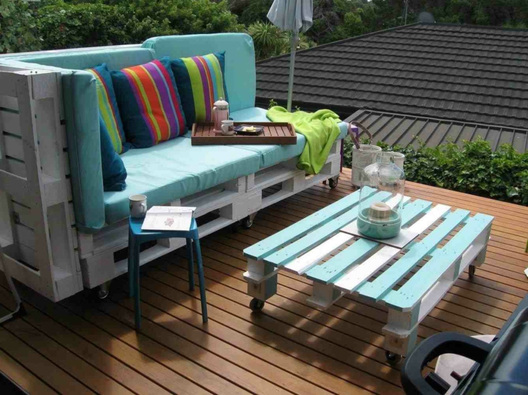 outdoor con un pallet arredamento composto da un tavolino e da un divano verniciati di bianco con cuscini colorati