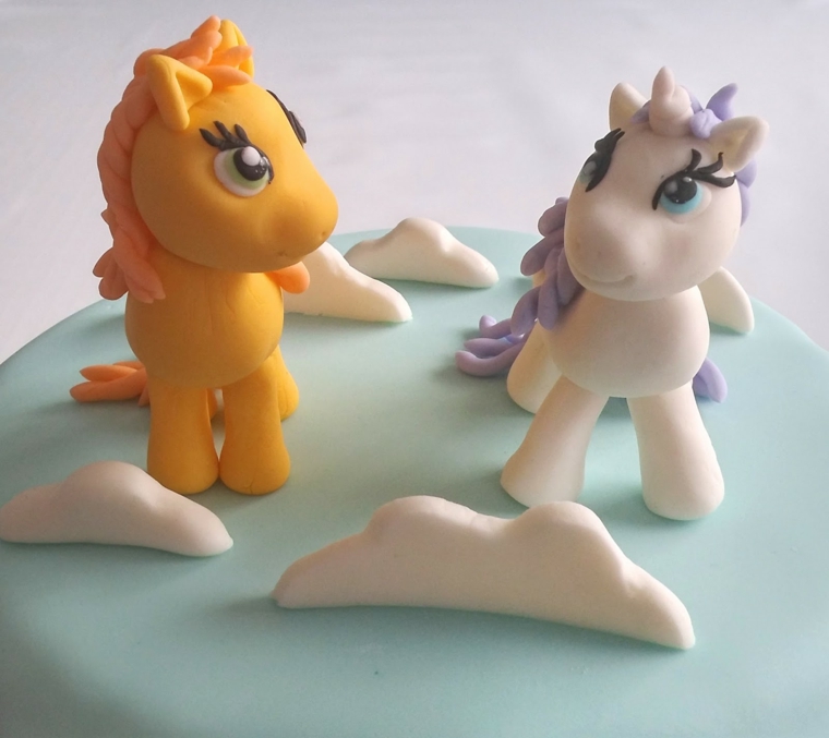 Torte di compleanno semplici, due pony come decorazione di un dolce con pasta di zucchero 
