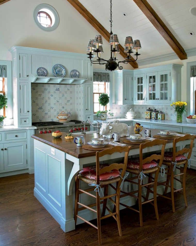 bellissima proposta di cucina shabby con mobili azzurro pastello, travi a vista e sedie in legno