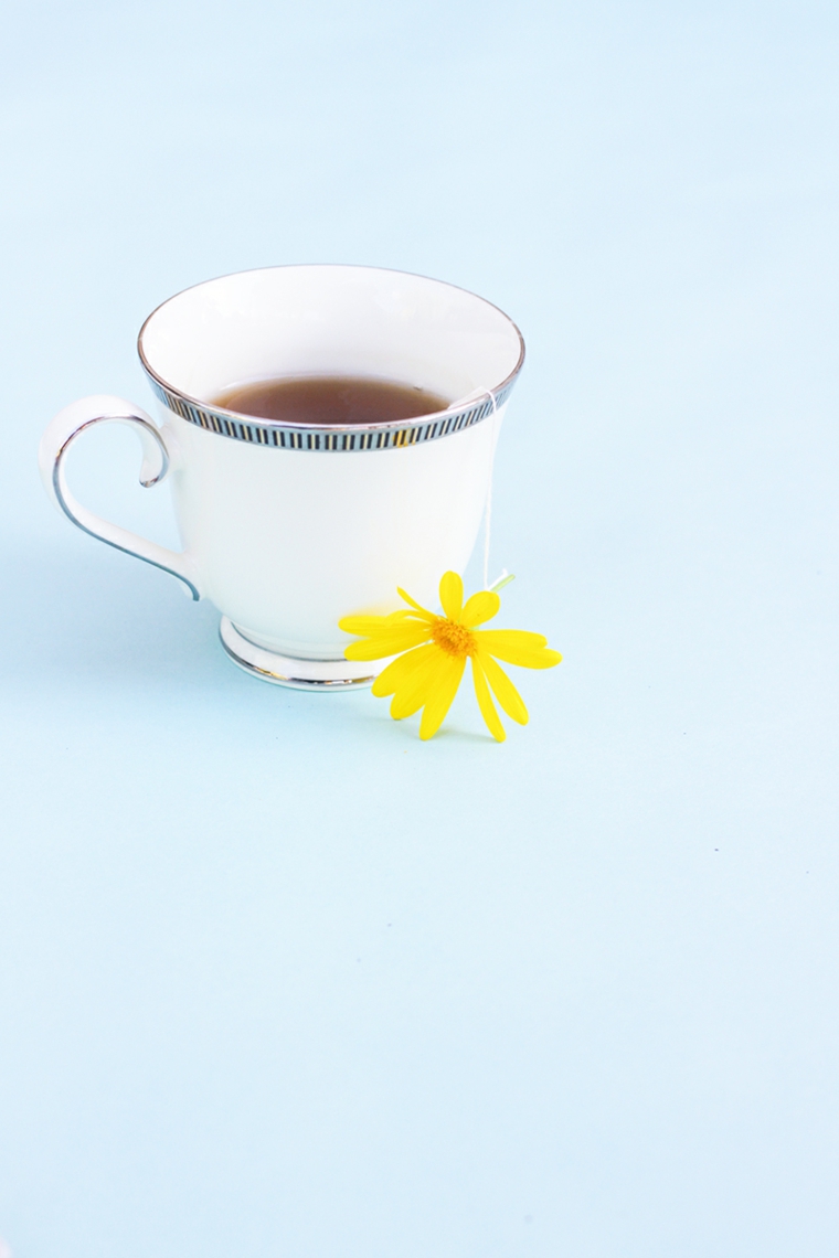 tazza di tè con all'interno una bustina decorata con un fiore giallo, idea per lavoretti festa della mamma