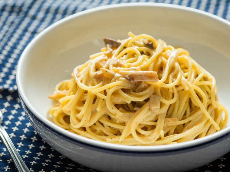 Cosa preparare per cena, spaghetti con le verdure e funghi, piatto tondo di colore bianco 