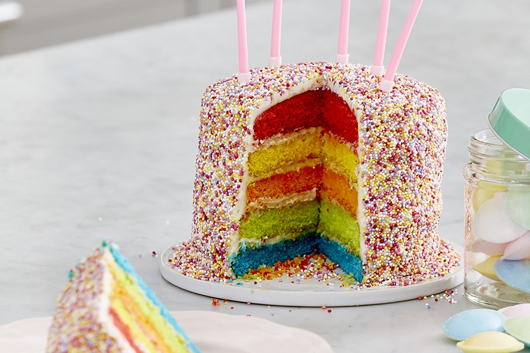 Idea torte di compleanno per bambini, strati colorati ad arcobaleno e fuori ricoperta di granelli di zucchero colorati 