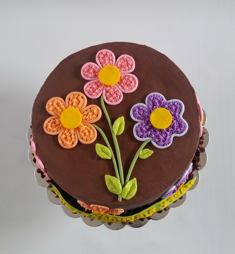 Torte bellissime, idea con un rivestimento di cioccolato e decorata con fiori colorati 