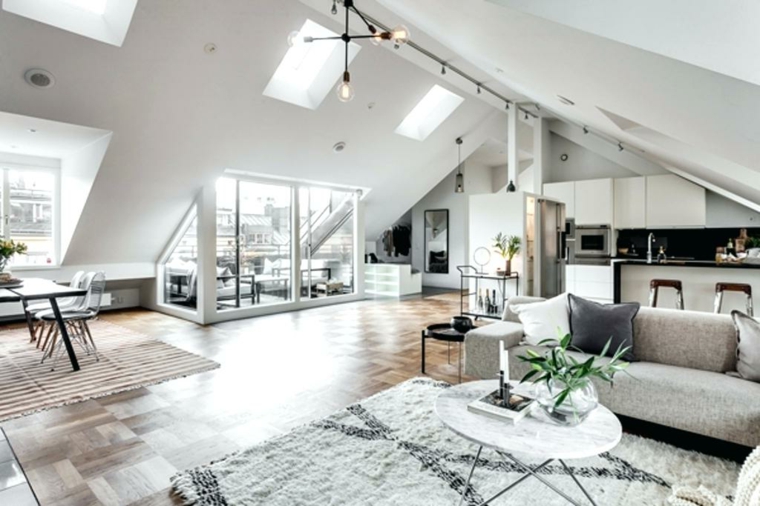 appartamento open space con cucina a vista bianca, divano melange e un grande tappeto grigio