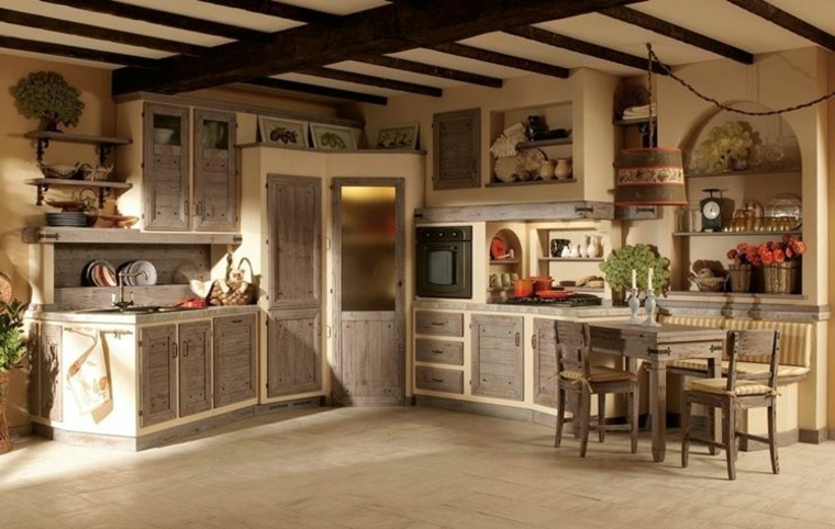 ampia cucina rustica in muratura con ante in legno grigio e struttura color panna, tavolo in legno