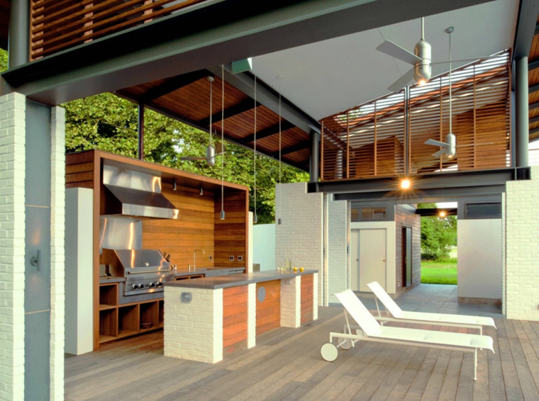 cucina esterna in muratura patio coperto con pavimento in legno due sdrai bianchi