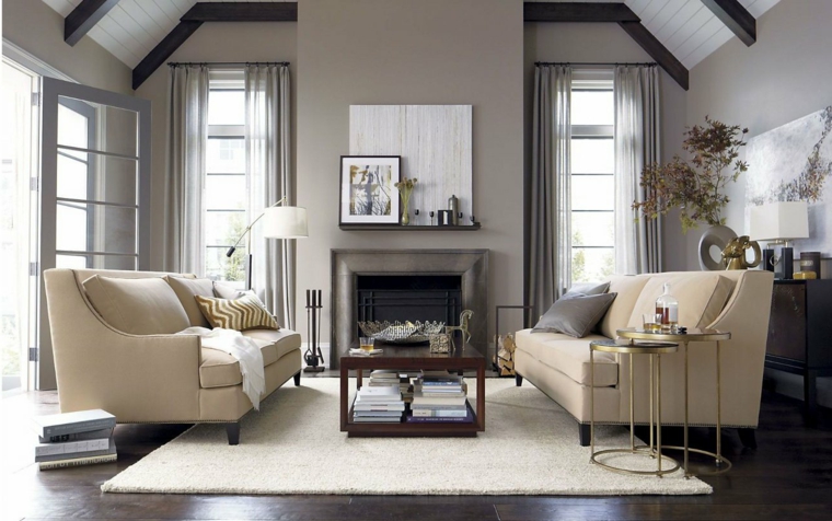 salotto dall'arredamento elegante e raffinato con divani e tappeto bianco e pareti color tortora chiaro