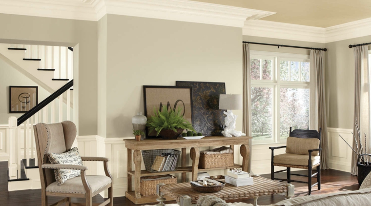 soggiorno con mobili in legno chiaro, tavolino, quadri e pareti color tortora chiaro