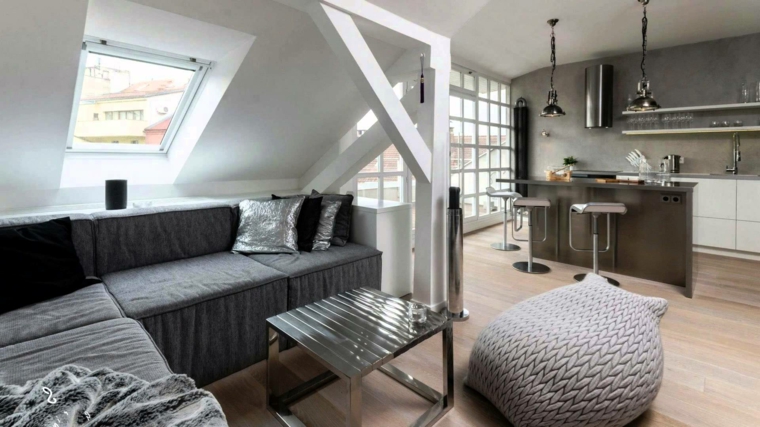 soluzione moderna per mansarda open space con cucina con isola e sgabelli, divano grigio