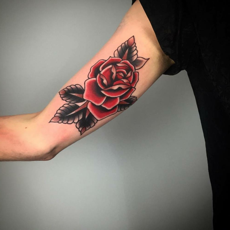 bellissimo tatuaggio rosa uomo rossa con delle grandi foglie nella parte interna del braccio