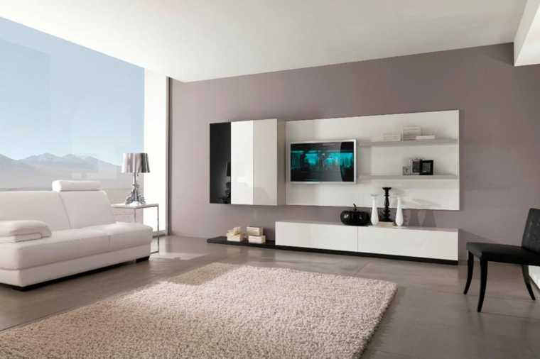 zona living dal design ultra moderno con divano in pelle bianco, tappeto beige, poltrona nera e pareti color tortora chiaro