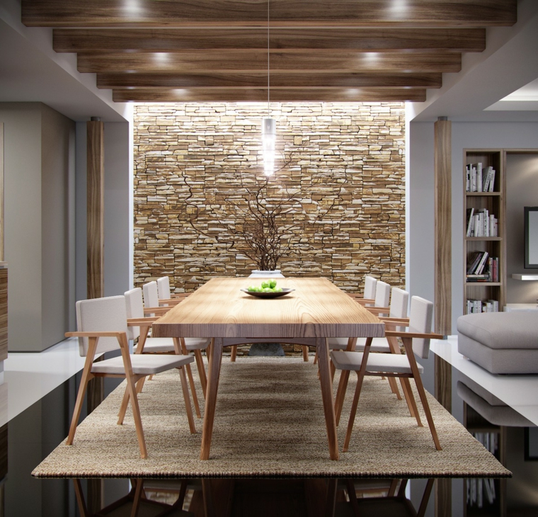 ampia zona pranzo con tavolo rettangolare in legno e sedie bianche, tappeto e muri in pietra