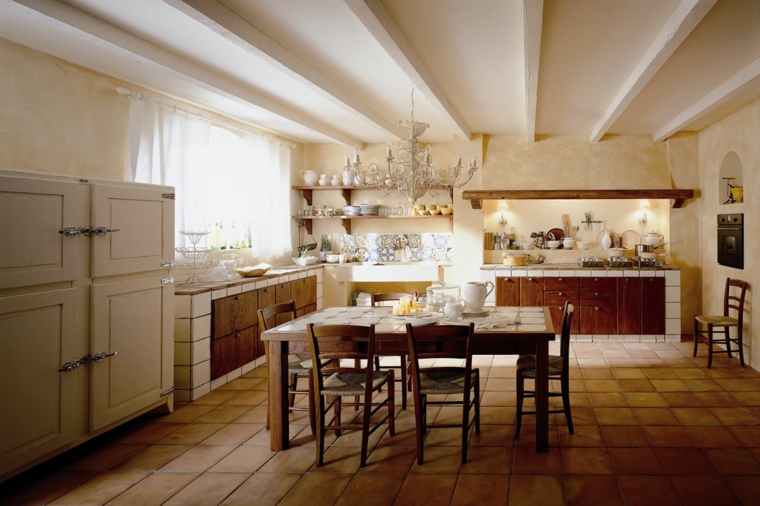 soffitto bianco con travi, cucina rustica in muratura con ante in legno e tavolo centrale