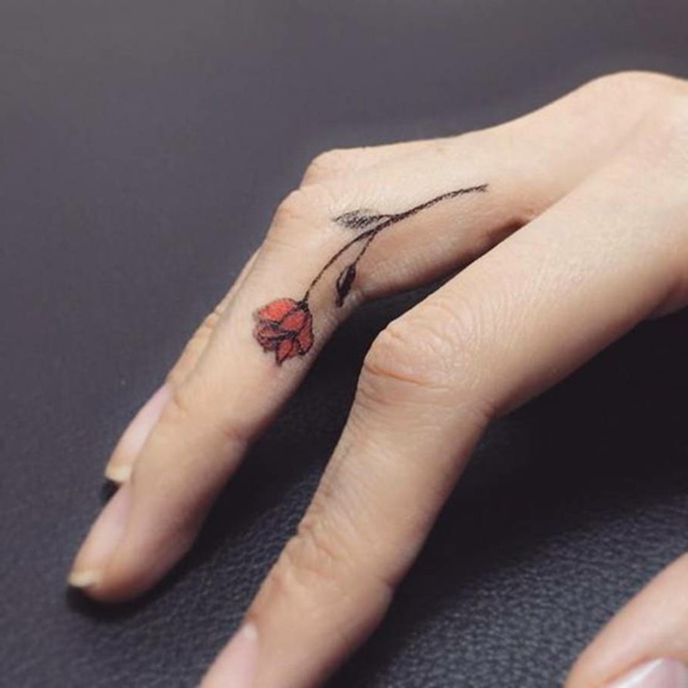 grazioso tattoo all'interno del dito medio, idea per un tatuaggio rosa rossa 