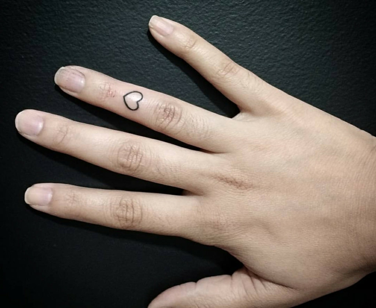 esempio per tatuaggio cuore piccole sul dito anulare nella parte frontale della mano di una ragazza
