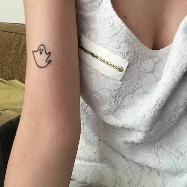 simpatico disegno di un piccolo fantasma stilizzato sul braccio dei una ragazza, immagini piccoli tatuaggi