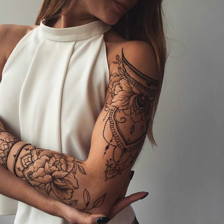 Tatuaggio fiore di loto su tutto il braccio di una donna, tattoo manica simbolo mandala