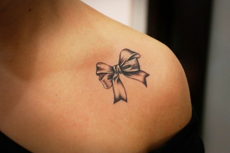 bellissimo fiocchetto in bianco e nero sulla spalla di una ragazza, idea tatuaggi bellissimi piccoli