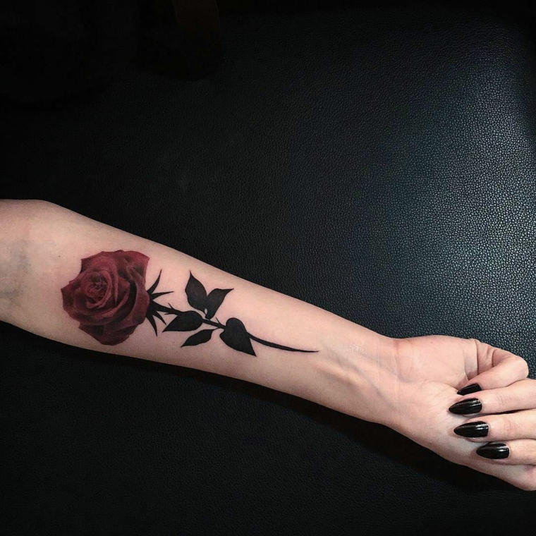splendida proposta per un tatuaggio rose rosse all'interno del braccio con gambo e foglie
