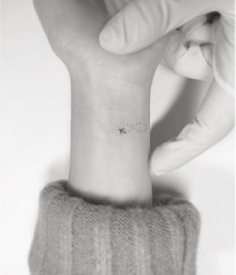 Tatuaggio piccolo sul polso della mano di una donna con il simbolo dell'infinito a puntini