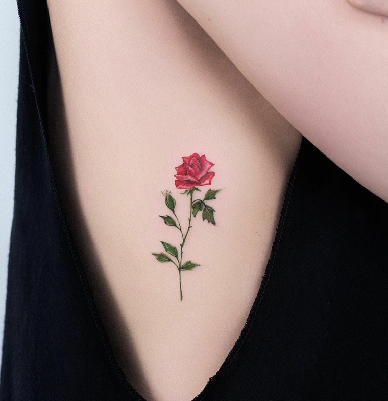 bellissima idea per tatuaggi rose piccole colorate con petali rossi e gambo e foglie verdi