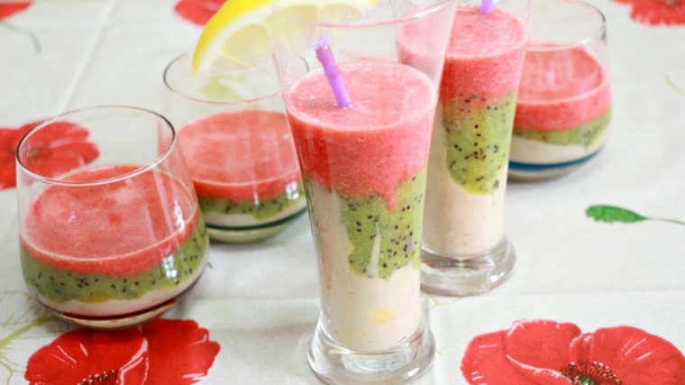 Bicchieri di vetro con frullati a strati di anguria e kiwi con una base di yogurt