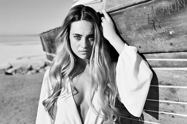 immagine in bianco e nero di una ragazza in spiaggia con i capelli lunghi, come fare come fare capelli ondulati