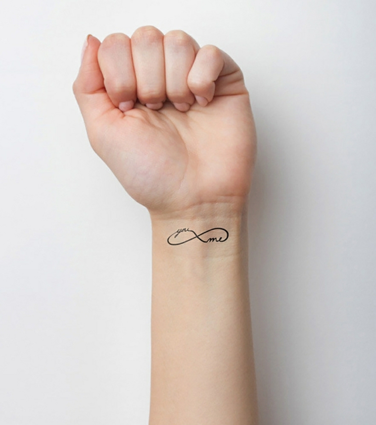 Tatuaggio piccolo sul polso della mano con il simbolo dell'infinito e una scritta