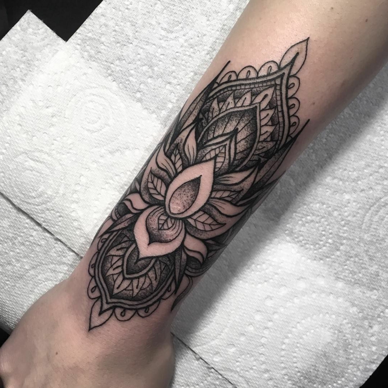 Donna tatuata sul braccio, fiore di loto tattoo significato, mano appoggiata su tovaglioli di carta