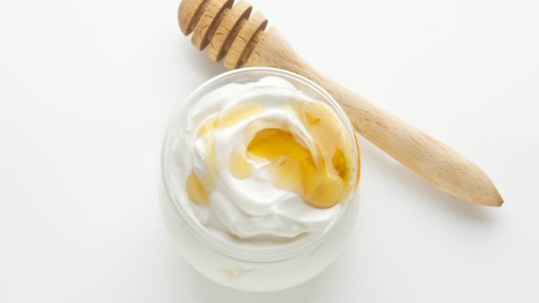 Pulizia del viso fai da te, ciotola di vetro con yogurt e miele da applicare sulla pelle