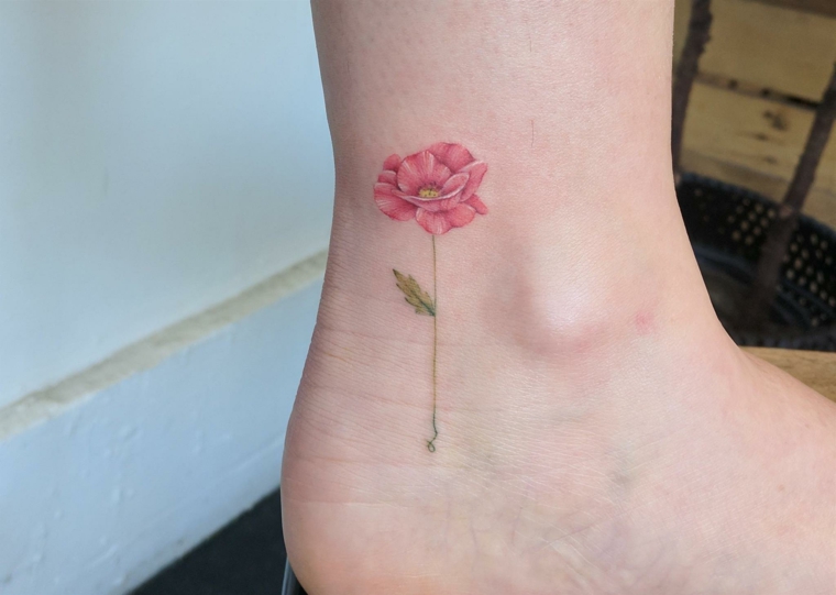 Tattoo caviglia con un fiore colorato di rosa con stelo verde