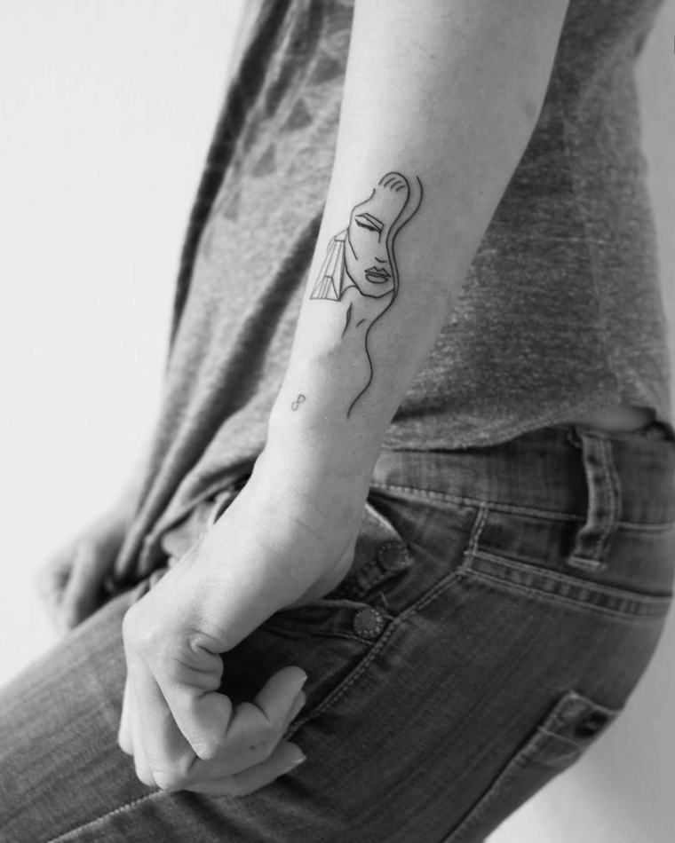 Idea per dei tatuaggi femminili braccio con il disegno di una donna e piccolo simbolo dell'infinito