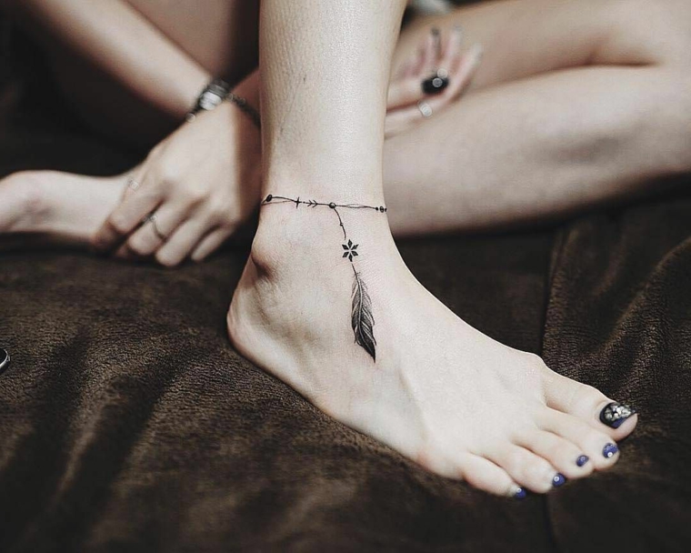 La caviglia di una donna con un tattoo bracciale e piuma, tatuaggi simboli dalle dimensioni piccole 