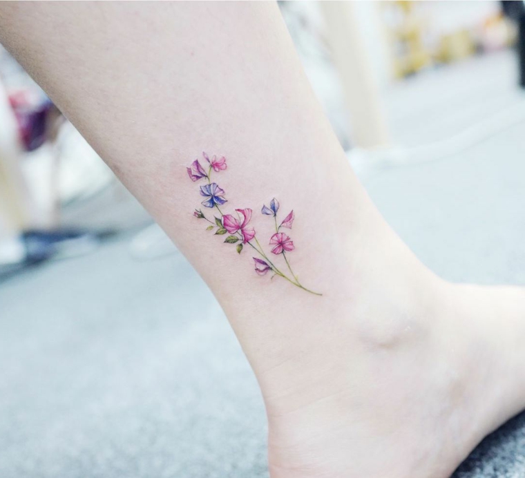 Idee tatuaggi piccoli, tattoo colorato con disegno di fiori sulla caviglia di una donna