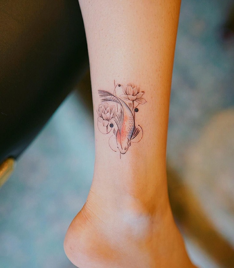 Tatto caviglia di una donna con un pesce colorato e fiore di loto intorno 