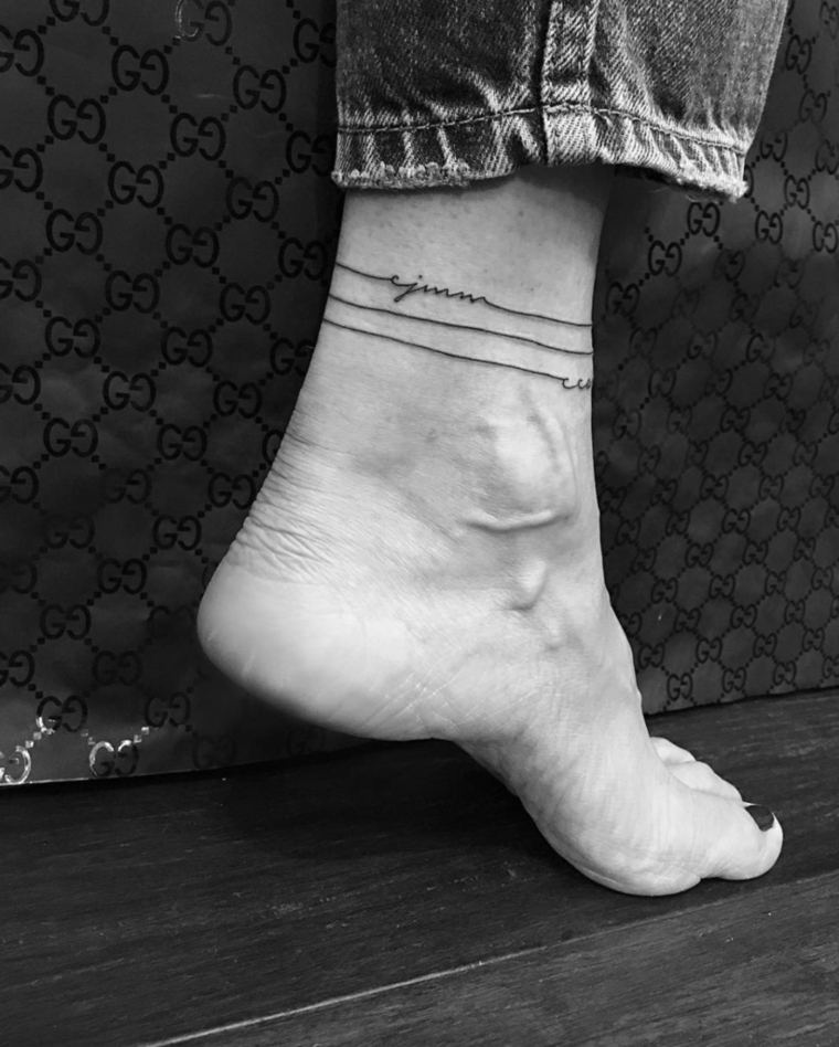 Tatuaggi alla caviglia femminili, donna con un tatto tipo bracciale e piccola scritta