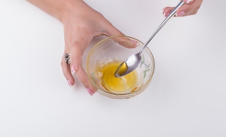 Come fare lo scrub a base di miele, ingredienti in una ciotola di vetro e mescolato con un cucchiaio