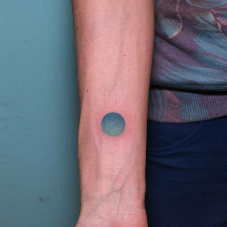 Disegni per dei tatuaggi avambraccio di una donna con un cerchio azzurro colorato