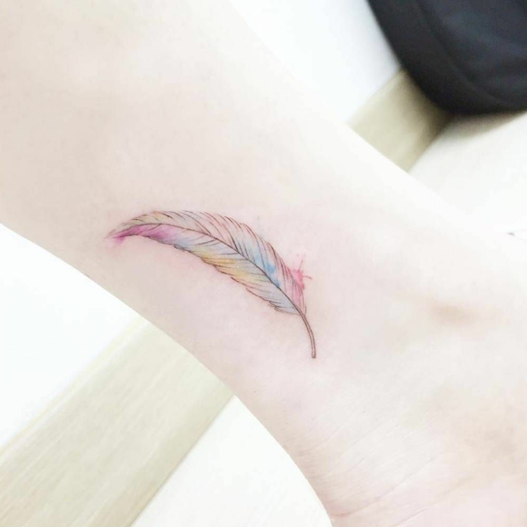 Idea per dei tatuaggi simboli, un piccolo tattoo sulla caviglia di una donna con piuma colorata