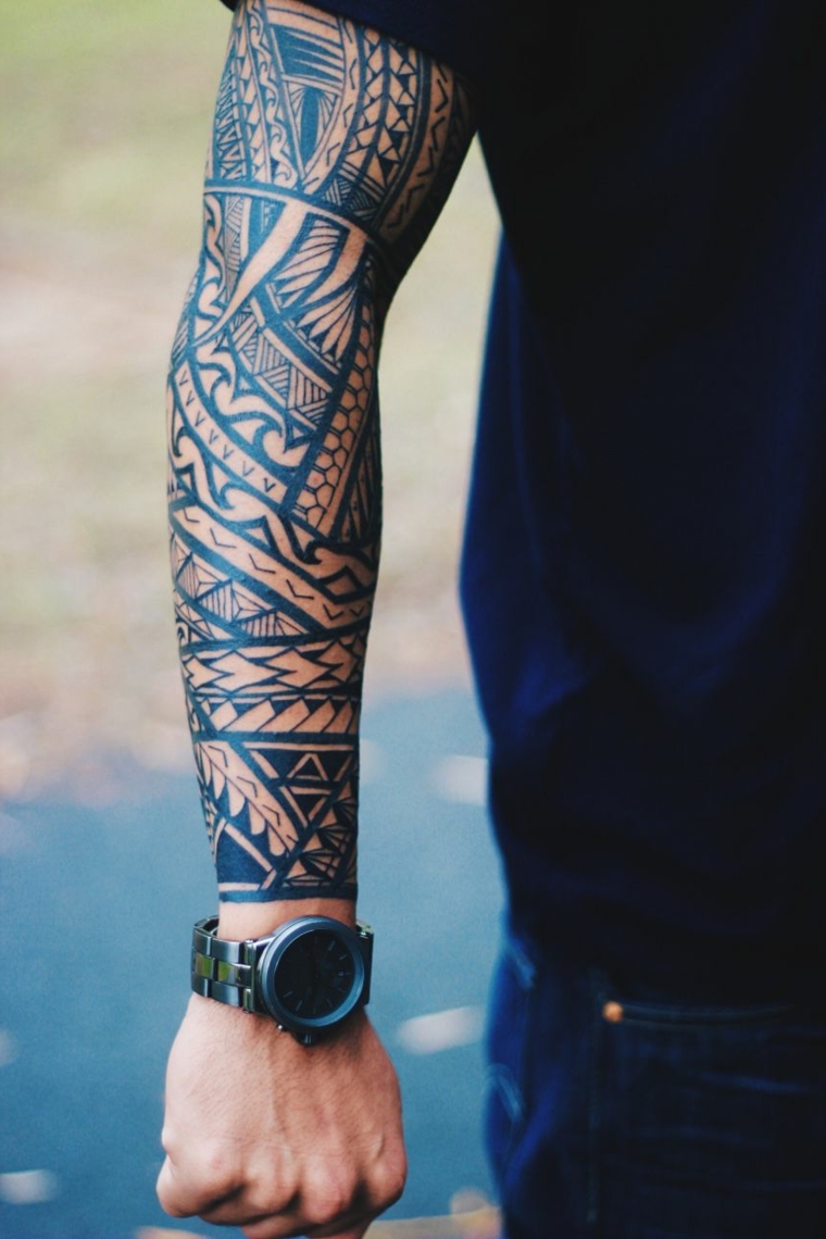 Uomo con un tatuaggio braccio grandissimo, tattoo maori come manica 