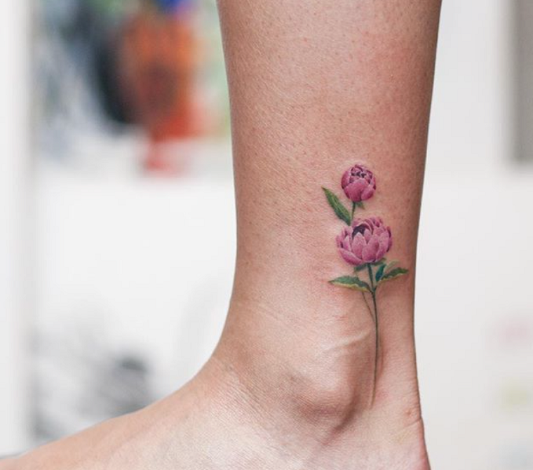 Disegno colorato di un tattoo colorato, tatuaggi con significato e un fiore di colore rosa e stelo verde