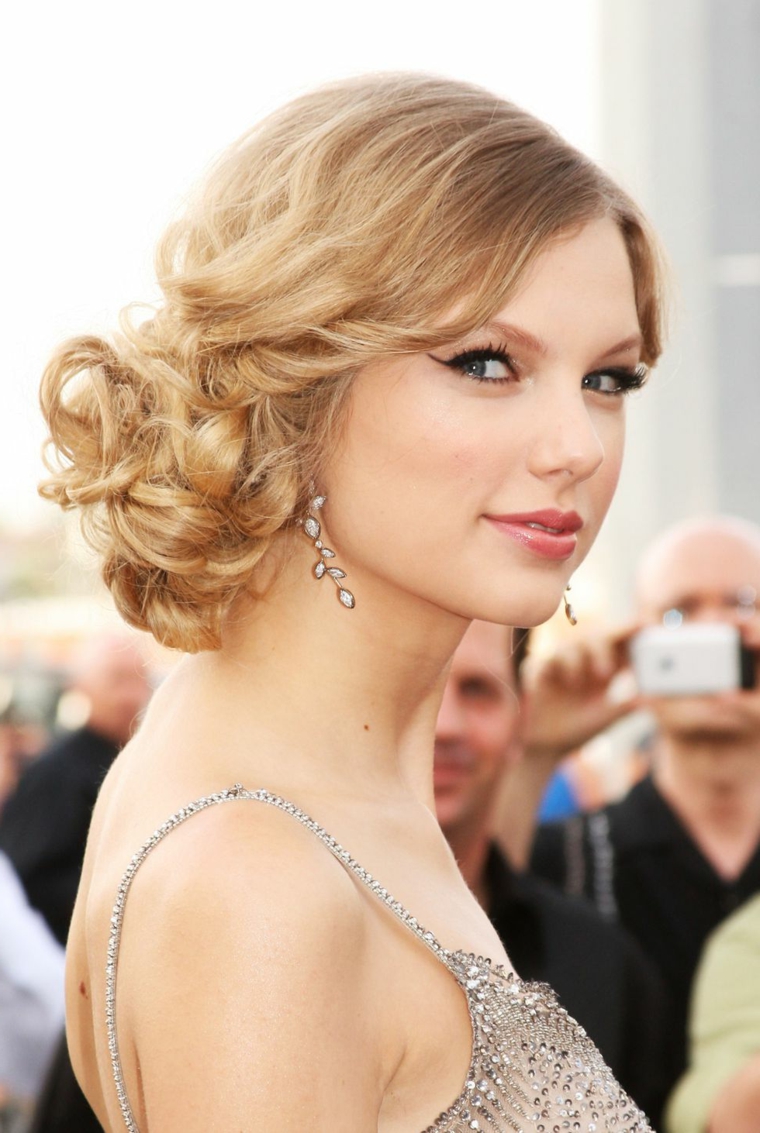 Pettinature capelli lunghi medi di colore biondo con un raccolto della cantane Taylor Swift