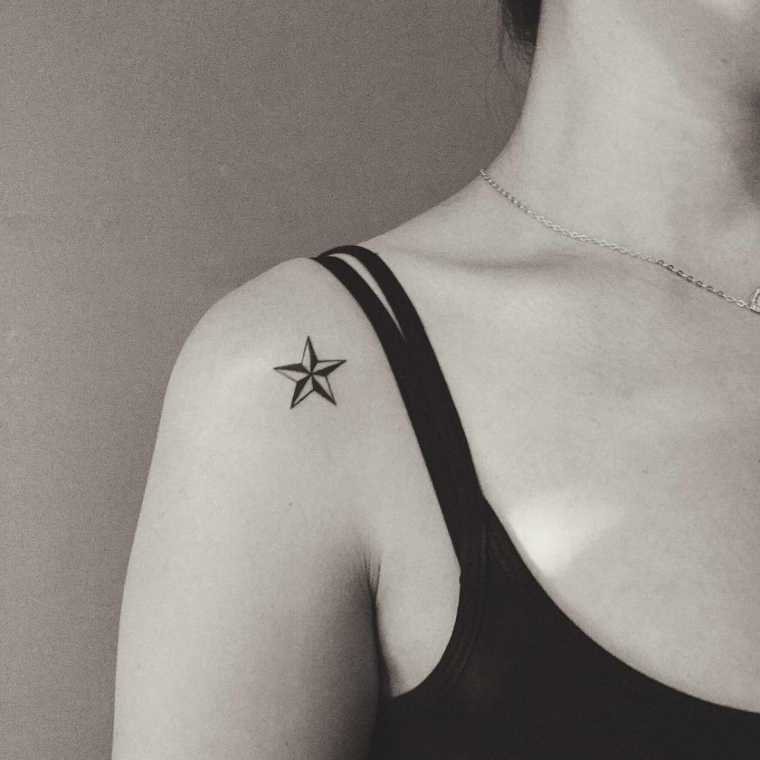 Tatuaggio stella significato sulla spalla di una donna, piccolo tatto con sfumature nere