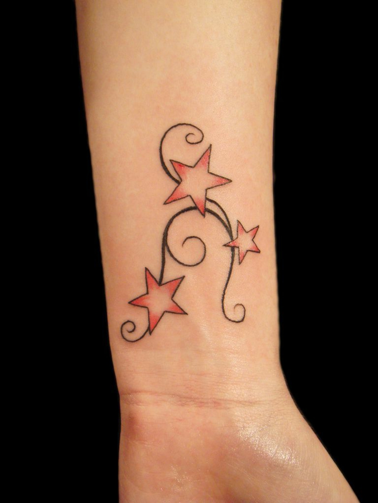 Tattoo particolari e un'idea con disegno colorato sul polso della mano di una donna